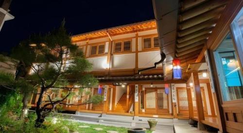 a large wooden building with a tree in front of it at Nabijam Hanok Hotel in Jeonju