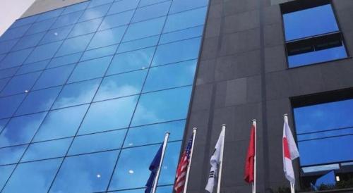 a group of flags standing in front of a building at CS Premier Hotel in Seoul
