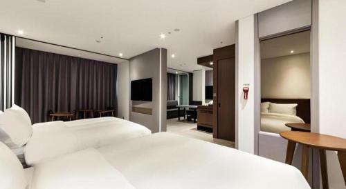 a hotel room with two beds and a television at CS Premier Hotel in Seoul