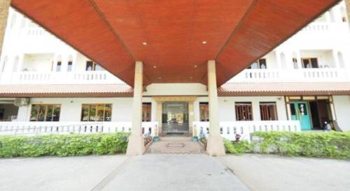 a large white building with a large red roof at AmornSukhothai Hotel in Sukhothai