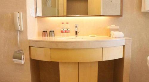 a bathroom with a sink and a mirror at Shanghai Fuyue Hotel in Shanghai