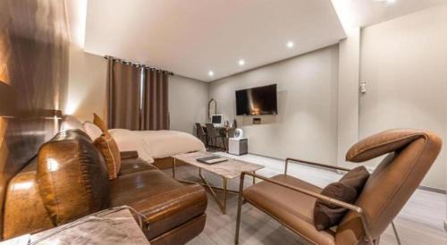 a hotel room with a couch and a bed at Cheongju Maryjane Hotel in Cheongju