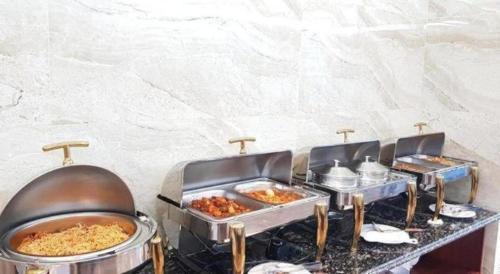 a buffet with three trays of food on a table at BACNINH HARMONY HOTEL in Bắc Ninh