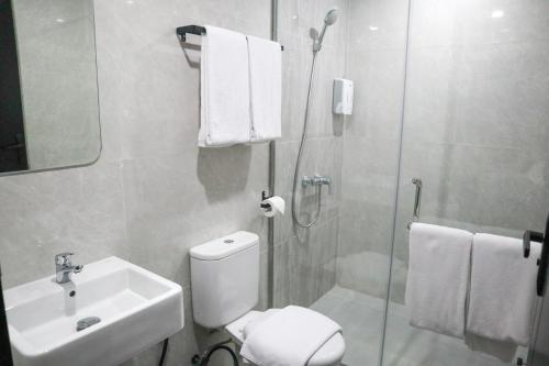 KlapalimaにあるCommodious Hotel Kupangのトイレ、洗面台、シャワー付きのバスルーム