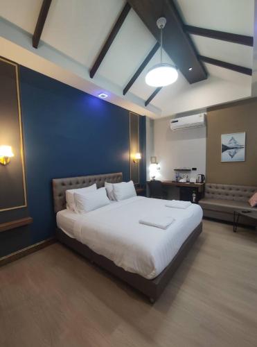 a bedroom with a large bed with a blue wall at อยู่สบายวิลล่า ยโสธร in Yasothon