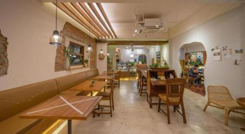 a restaurant with tables and chairs in a room at Need a Nap Hostel Phrae in Phrae