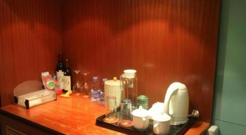 a counter with a coffee maker and other items on it at Golden Central Hotel Shenzhen in Shenzhen