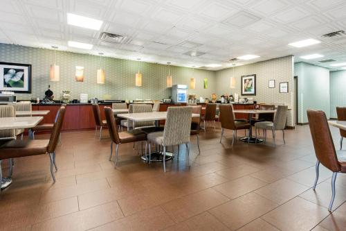 a dining room with tables and chairs in a restaurant at Quality Inn & Suites Charleston - Civic Center in Charleston