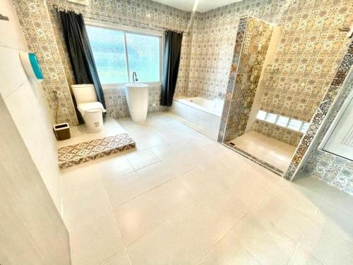 Un baño con ducha, inodoro y lavabo. en Oasis Hiso Hotel, en Ban Nong Pla Duk