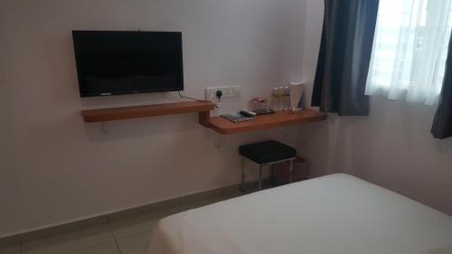 a bedroom with a bed and a tv on a wall at DOTA Hotel in Alor Setar