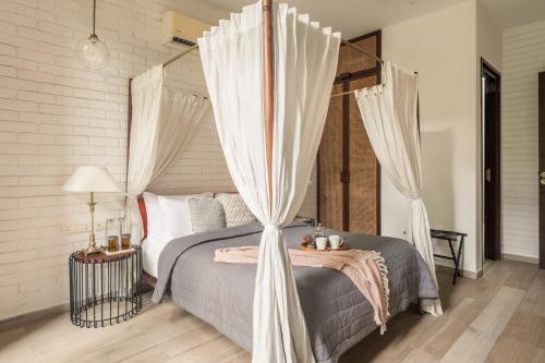 a bedroom with a canopy bed with curtains at La Zamora, 3BHK Villas near Vagator & Anjuna Beach, North Goa with Private Pool, Garden, Terrace & Security in Assagao