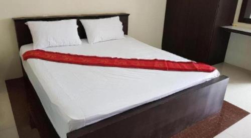 a bed with a red blanket on top of it at OYO 75399 Choktipparat Place in Udon Thani