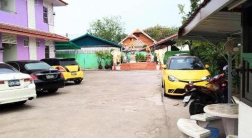 a group of cars parked in a parking lot at OYO 75399 Choktipparat Place in Udon Thani