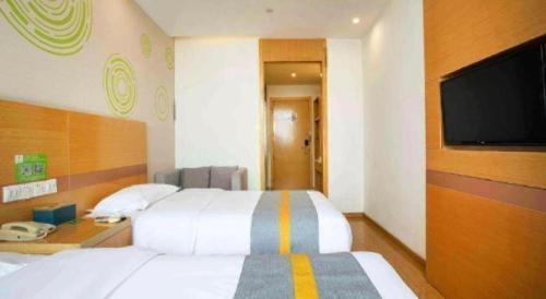 a bedroom with a white bed and a flat screen tv at GreenTree Inn Shanghai National Convention and Exhibition Center Huaxiang Road in Shanghai