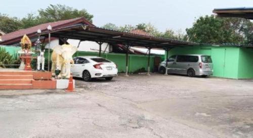 two cars parked in a parking lot next to a building at OYO 75399 Choktipparat Place in Udon Thani