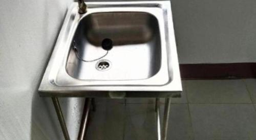 a white sink in a corner of a wall at OYO 75399 Choktipparat Place in Udon Thani