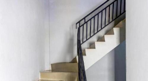a staircase in a white building with a metal railing at OYO 91296 Nagoya Guesthouse in Nagoya