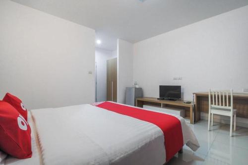 a bedroom with a bed and a desk with a computer at Super OYO 662 Malee Bunga Hotel in Si Racha