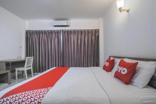 a bedroom with a large bed with red and white pillows at Super OYO 662 Malee Bunga Hotel in Si Racha