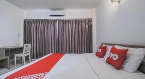 a bedroom with a large bed with red and white pillows at Super OYO 662 Malee Bunga Hotel in Si Racha