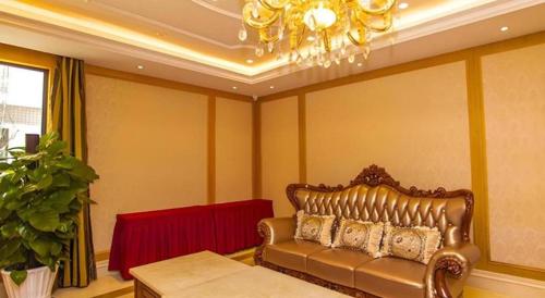 a living room with a couch and a chandelier at Vienna Hotel Shenzhen Bao'an Airport Taoyuanju Pingluanshan Metro Station in Shenzhen