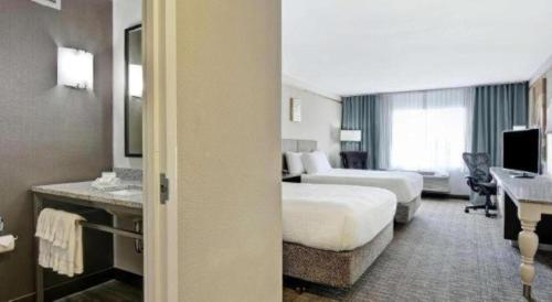 a hotel room with two beds and a desk at Hilton Garden Inn Oshkosh in Oshkosh