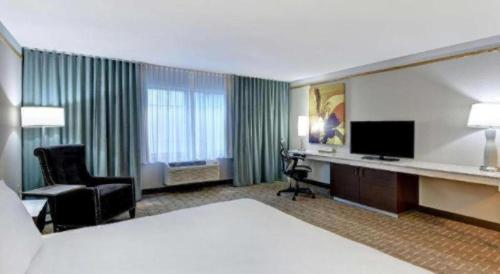 a hotel room with a bed and a desk with a television at Hilton Garden Inn Oshkosh in Oshkosh