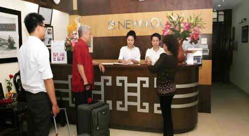 a group of people standing at a counter in a store at New Moon Hotel in Hanoi