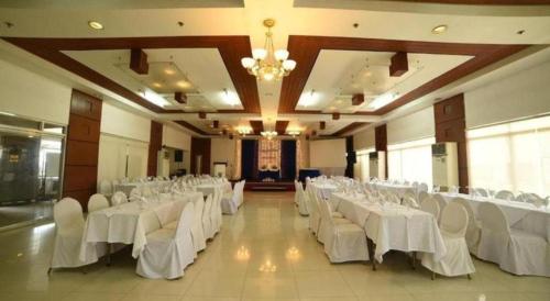 a banquet hall with white tables and white chairs at Marcian Business Hotel in Zamboanga
