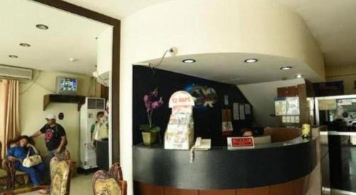 a mirror in a room with a counter and people at Marcian Business Hotel in Zamboanga