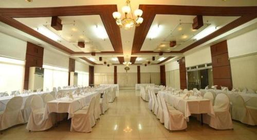a large banquet hall with white tables and white chairs at Marcian Business Hotel in Zamboanga
