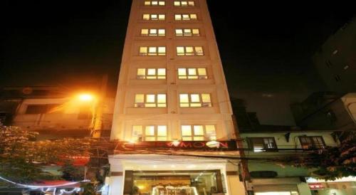 a tall white building with a lot of windows at New Moon Hotel in Hanoi