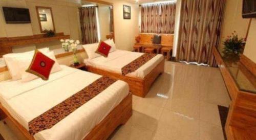 a hotel room with two beds in a room at Lucky Star Hotel in Phnom Penh