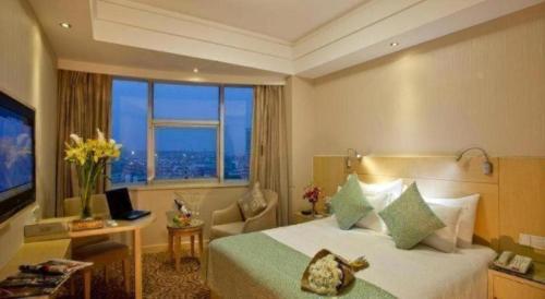 a hotel room with a bed and a large window at Huachen Kenzo Hotel Hangzhou in Hangzhou