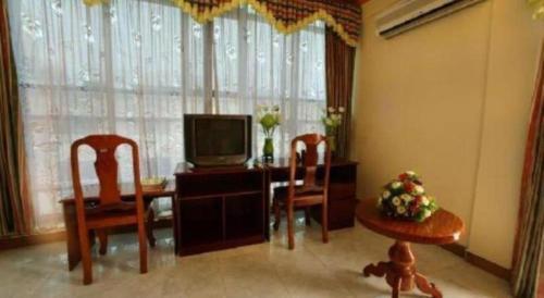 a living room with a television and a table and chairs at Lucky Star Hotel in Phnom Penh