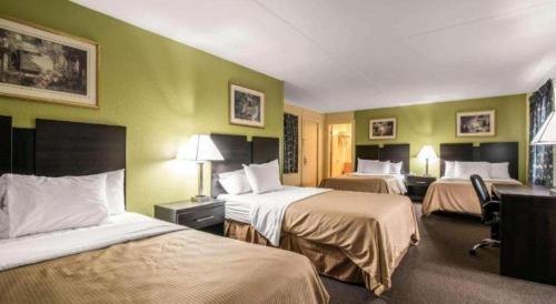 a hotel room with two beds with green walls at Rodeway Inn in Rutland