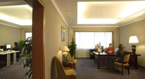 a lobby with people sitting at a desk in a hotel at Capital Hotel in Beijing