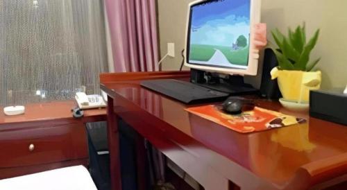 a desk with a computer monitor on top of it at New Friendship Hotel in Luoyang