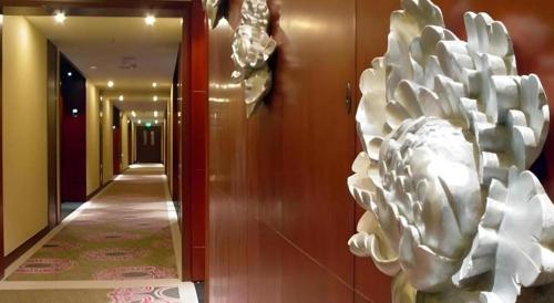 a hallway with a white sculpture on the wall at New Friendship Hotel in Luoyang