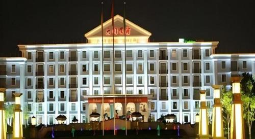 a large white building with a flag in front of it at Datong Hotel in Datong