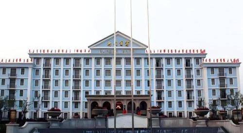 a large blue building with a flag on top of it at Datong Hotel in Datong
