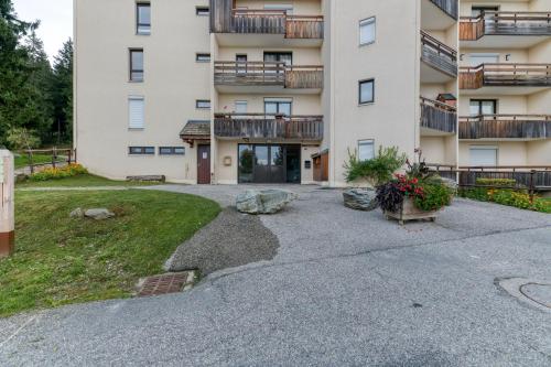 an apartment building with a driveway and a yard at Les sapins 1 in Les Adrets