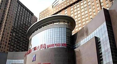 a building with a sign on it in front of buildings at Hohhot Hai Liang Plaza Hotel in Hohhot