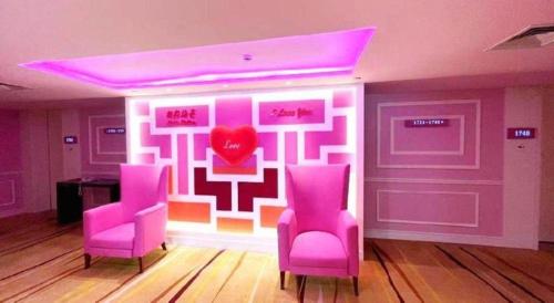 a room with pink chairs and a heart on the wall at Hohhot Hai Liang Plaza Hotel in Hohhot