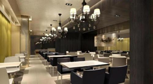 a dining room with white tables and chairs and chandeliers at Jinjiang Inn Weihai High Speed Qingdao South Road in Weihai