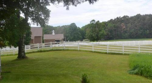 a white fence in a field next to a house at Birchwood Inn in Harbor Springs
