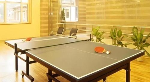 a ping pong table in a living room with ahibition at Beijing Friendship Hotel Jing Bin Building in Beijing