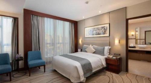 a large hotel room with a bed and a bathroom at Grand Soluxe Zhongyou Hotel Shenzhen in Shenzhen