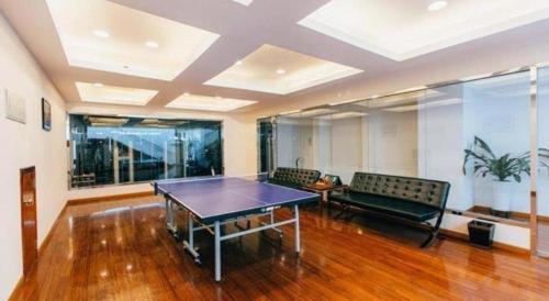 a living room with a ping pong table and benches at Grand Soluxe Zhongyou Hotel Shenzhen in Shenzhen
