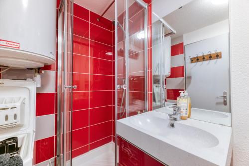 a bathroom with a sink and red tiles at Le May'hé - Studio Cabine Et Balcon in Les Adrets